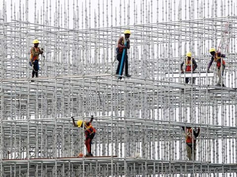 Construction workers seen on scaffolding for a bridge made for the coastal road project at Hajji Ali in Mumbai. India is focusing on infrastructure investments to bolster industrial demand 