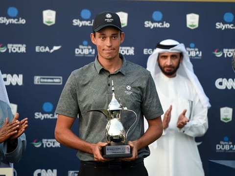 Dubai-based golfer Josh Hill receiving his award for top amateur at the Slync.io Dubai Desert Classic at Emirates Golf Club 