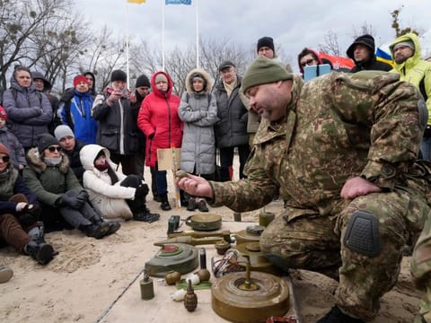 An instructor, right, shows a grenade during a training of members of a Ukrainian far-right group train, in Kyiv on February 20, 2022. 