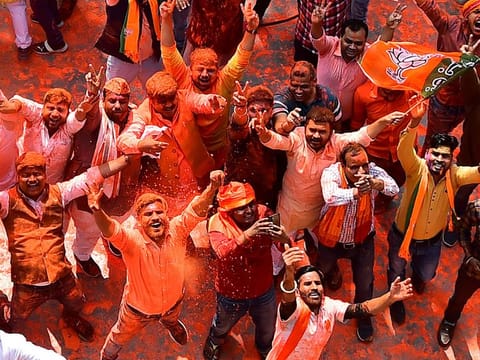 Supporters of India's Bharatiya Janata Party (BJP) celebrate outside the party office in Lucknow on March 10, 2022, on the day of counting of votes for the Uttar Padesh state asembly elections. 