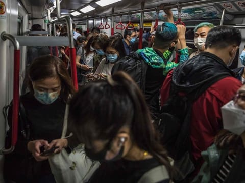 People commute on a train in Hong Kong on March 15, 2022. 