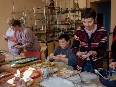 Volunteers prepare varenyky, stuffed dumplings, inside a theatre in the city of Drohobych, western Ukraine, Monday, March 21, 2022. The theatre has become a meeting point, where artistes, including those displaced from other parts of Ukraine, have turned their talents to making food for soldiers and others as part of a massive volunteer war effort across the country. 