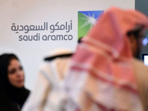 File photo: Saudi and foreign investors stand in front of the logo of Saudi state oil giant Aramco during the 10th Global Competitiveness Forum in the capital Riyadh. 
