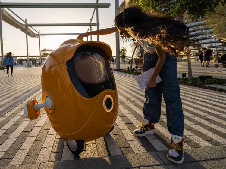 A visitor interacts with Opti the robot at the Mobility District_Large Image_m47879-1648288473646
