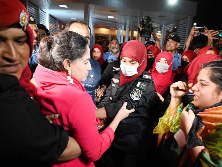 Female police officers detain supporters of Imran Khan’s party outside parliament house in Islamabad