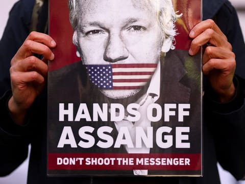 A supporter of Julian Assange displays a placard, outside the Westminster Magistrates' Court in London, on April 20, 2022.  