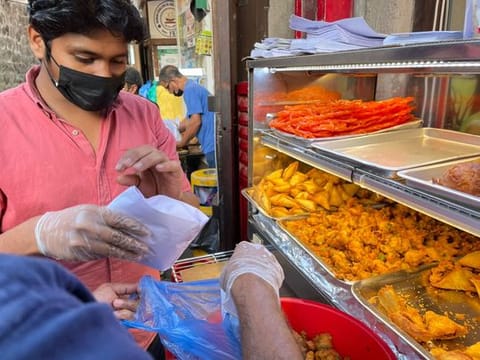 Plates of hot, crunchy samosas (deep-fried savoury snacks with filling), pakoras (fritters) and wadas (deep-fried lentil-based fritters) are up for sale