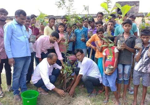 Gajendra (left) engaged in plantation drive along with the villagers and children.