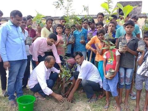 Gajendra (left) engaged in plantation drive along with the villagers and children.