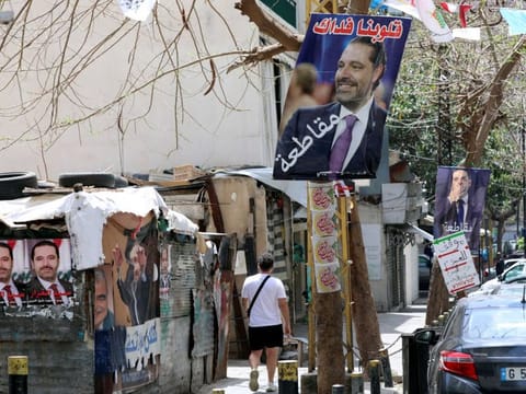 A man walks past posters depicting Lebanon's former Prime Minister Saad Hariri, ahead of the parliamentary election on May 15, in Beirut.
