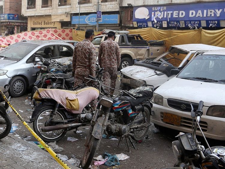 Pakistani paramilitary soldiers examine the cordon-off site of Thursday’s night bomb explosion, in Karachi, on  May 13, 2022. 