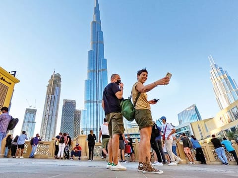 All food service providers, coronavirus patients and suspected cases must wear masks. A visitor taking a selfie near Burj Khalifa, the world's tallest tower in Dubai; photo for illustrative use only.