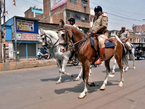 Police officials talk to religious leaders after violence erupted between two groups at the Parade Chauraha area, in Kanpur on Saturday. 
