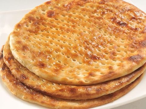 Sheermal - A soft round bread, mildly sweetened with scents of rose water and saffron with its iconic holes 