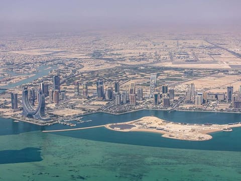Residential and commercial skyscrapers on the city shoreline in Doha, Qatar.  The donations will include whole football stadiums, thousands of stadium seats and buses. Qatar had purchased around 3,000 buses, in addition to the 1,000 buses it already has, which were used to transport fans for free during the event.