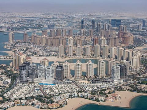 Residential and commercial skyscrapers on the city shoreline in Doha, Qatar.