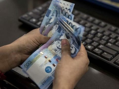 Philippine peso bills being counted at a foreign exchange centre. File photo.