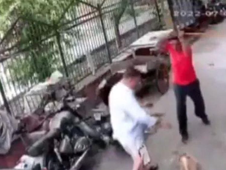 The Delhi man beating the dog (partly seen) with an iron pipe.