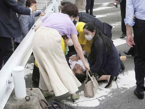 Former Japanese prime minister Shinzo Abe lies on the ground after after being shot during an election campaign for the July 10, 2022 Upper House election, in Nara, western Japan, on July 8, 2022.  