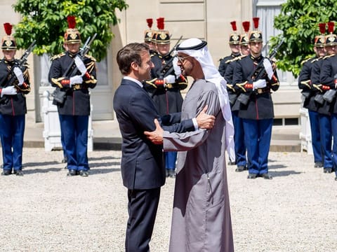 Sheikh Mohamed stands for a photograph with Emmanuel Macron and Brigitte Macron at the Elysee Palace.