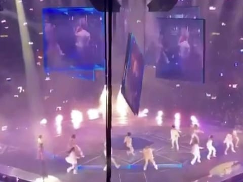 In this image made from video taken from social media, a video screen suspended above the stage falls onto the stage where dancers perform at a concert of Cantopop boy band Mirror in Hong Kong, Thursday, July 28, 2022.
