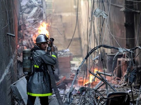 A Palestinian firefighter fights the blaze amid the destruction following an Israeli air strike on Gaza City, on August 5, 2022. 