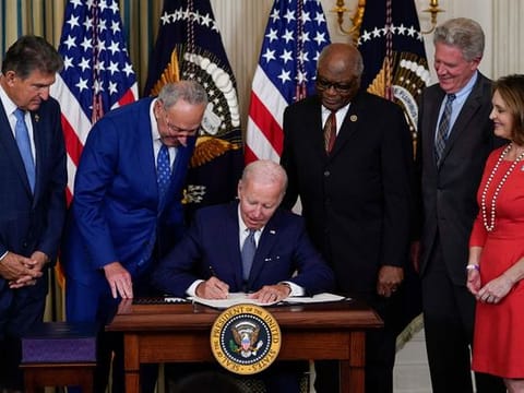President Joe Biden signs the landmark bill in the State Dining Room of the White House 