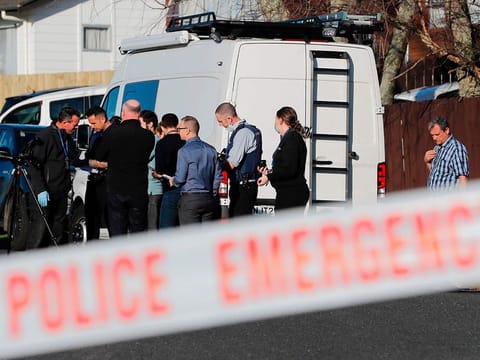 New Zealand police investigators work at a scene in Auckland on Aug. 11, 2022, after bodies were discovered in suitcases. 