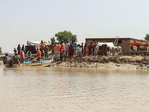 Pakistan army soldiers arrive to evacuate people stranded at a flooded area after heavy monsoon rains in Rajanpur district of Punjab province on August 27, 2022