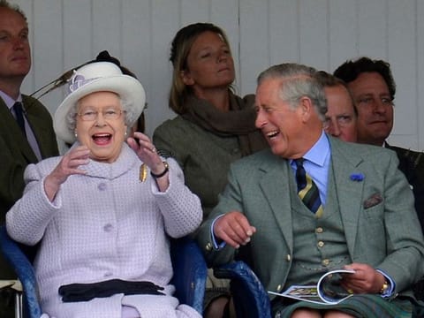 Members of Britain's royal family Queen Elizabeth and Prince Charles cheer as competitors participate in a sack race at the Braemar Gathering in Braemar, Scotland, Britain, September 1, 2012. 