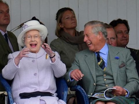 Members of Britain's royal family Queen Elizabeth and Prince Charles cheer as competitors participate in a sack race at the Braemar Gathering in Braemar, Scotland, Britain, September 1, 2012. 