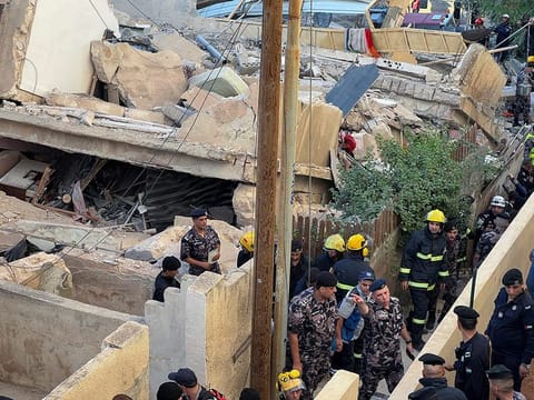 Rescuers work at the site of a residential building collapse in Amman on September 13, 2022. 