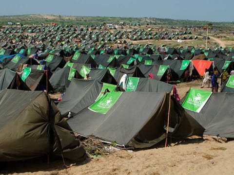 People from flood-affected areas walk between tents in a relief camp, in Chachro near Tharparkar, a district of southern Sindh province, Pakistan, Monday, Sept. 19, 2022.  
