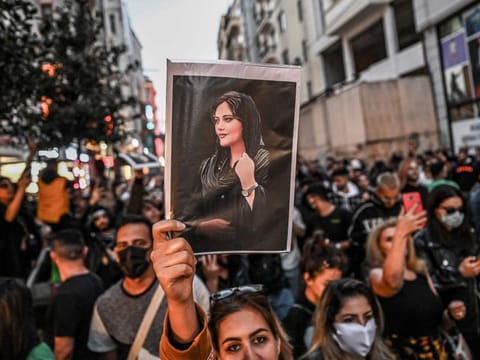 A protester holds a portrait of Mahsa Amini during a demonstration in support of Amini, a young Iranian woman who died after being arrested in Tehran by the Islamic Republic's morality police, on Istiklal avenue in Istanbul on September 20, 2022. 