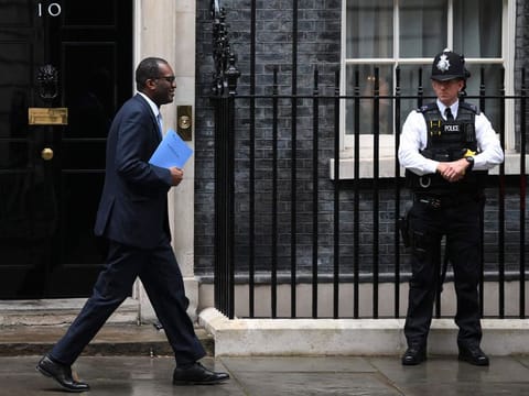 Kwasi Kwarteng holds a folder reading "The Growth Plan 2022" as he walks past Number 10 Downing Street on his way to unveil an anti-inflation budget plan in London on September 23, 2022