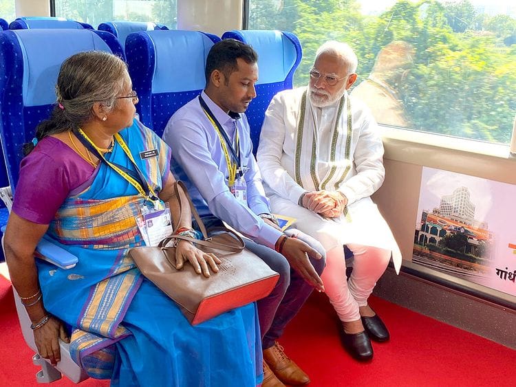 Prime Minister Narendra Modi interacts with Railway employees as they travel on board Vande Bharat Express train from Gandhinagar to Ahmedabad, on Friday. 