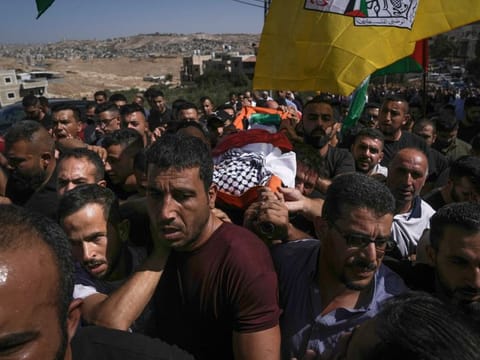 Mourners carry the body of 7-year-old Palestinian boy Rayan Sulaiman during his funeral in the West Bank village of Tequa near Bethlehem on September 30, 2022. 