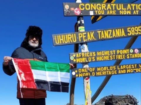 Raman Chander Sood, an Indian expat grandfather in Dubai aged 70, waving UAE flag after climbing Mount Kilimanjaro on October 15