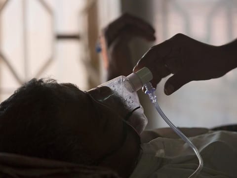 A relative adjusts the oxygen mask of a tuberculosis patient at a TB hospital on World Tuberculosis Day in Hyderabad, India (File)