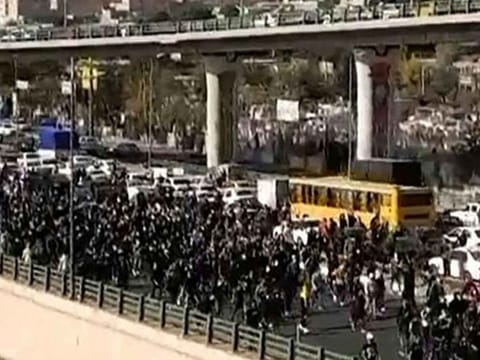 This image grab from a UGC video posted on November 3, 2022, reportedly shows protesters marching along a highway in Iran's northern city of Karaj, northwest of the capital, seemingly after a 40th day mourning ceremony held for a slain protester. 
