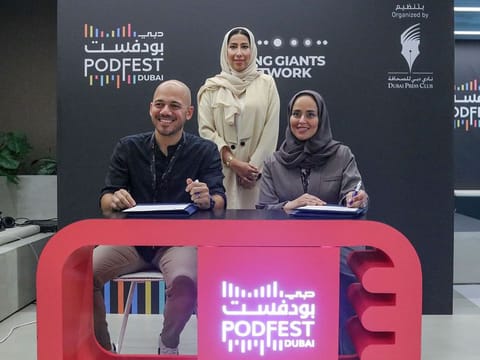 Mona Al Marri (centre), Vice Chairperson and Managing Director of the Dubai Media Council and President of the Dubai Press Club, witnessing the signing of the agreement by Dr Maitha Buhumaid (right), Director of the Dubai Press Club, and Basel Anabtawi (left), CEO of Rising Giants Network