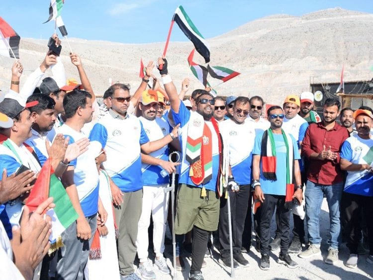 ndian amputee footballer Panakkadan Muhammed Shafeeq waves the UAE flag after he climbed the Jebel Jais mountain by using crutches on Sunday