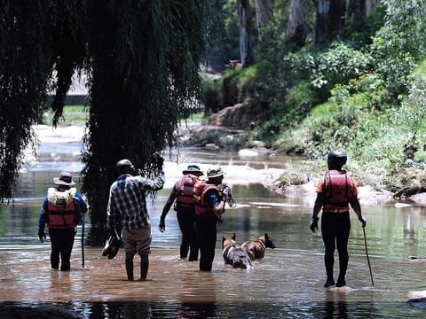 Rescue workers search the waters of the Jukskei river in Johannesburg.  Congregations often gather to conduct church rituals including cleansing and baptism along the Jukskei river which runs along many townships including Alexandra in the east of Johannesburg.