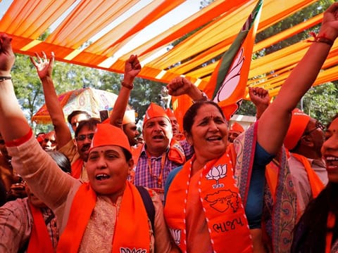 Supporters of India's ruling Bharatiya Janata Party (BJP) burn firecrackers to celebrate after learning of the initial poll results of Gujarat state assembly election in Gandhinagar, India, December 8, 2022. 
