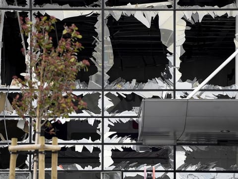 Broken windows of the terminal at Brussels national airport are seen during a ceremony following bomb attacks in Brussels metro and Belgium's National airport of Zaventem, Belgium, March 23, 2016. 