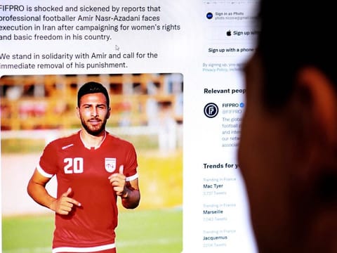 A person in the Cypriot capital Nicosia checks a tweet on December 13, 2022, by the International Federation of Professional Footballers (FIFPRO) regarding the reported risk of Iranian footballer Amir Nasr-Azadani being sentenced to death in connection with protests which have shaken the country for three months.  