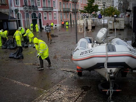 Municipal workers clean a street that was flooded overnight in Alges, just outside Lisbon, Tuesday, Dec. 13, 2022. An Atlantic storm slammed into the Iberian peninsula, leaving behind a trail of destruction Tuesday, especially in the Portuguese capital Lisbon, before moving eastward into Spain. 