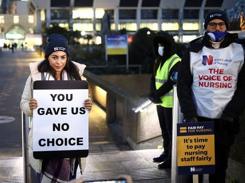 Nurses hold signs during a strike outside St Thomas' Hospital in London, Britain.
