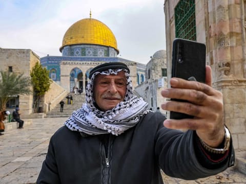 A man takes a "selfie" with the Dome of the Rock shrine at the Aqsa mosque compound iin Jerusalem on January 3, 2023. 