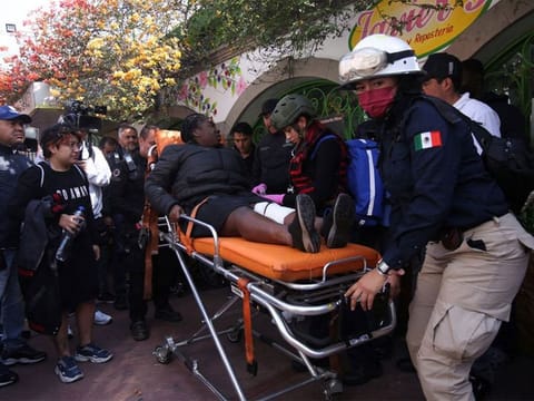 Paramedics assist a woman after two subway trains collide head-on at a subway station, in Mexico City, Mexico, January 7, 2023